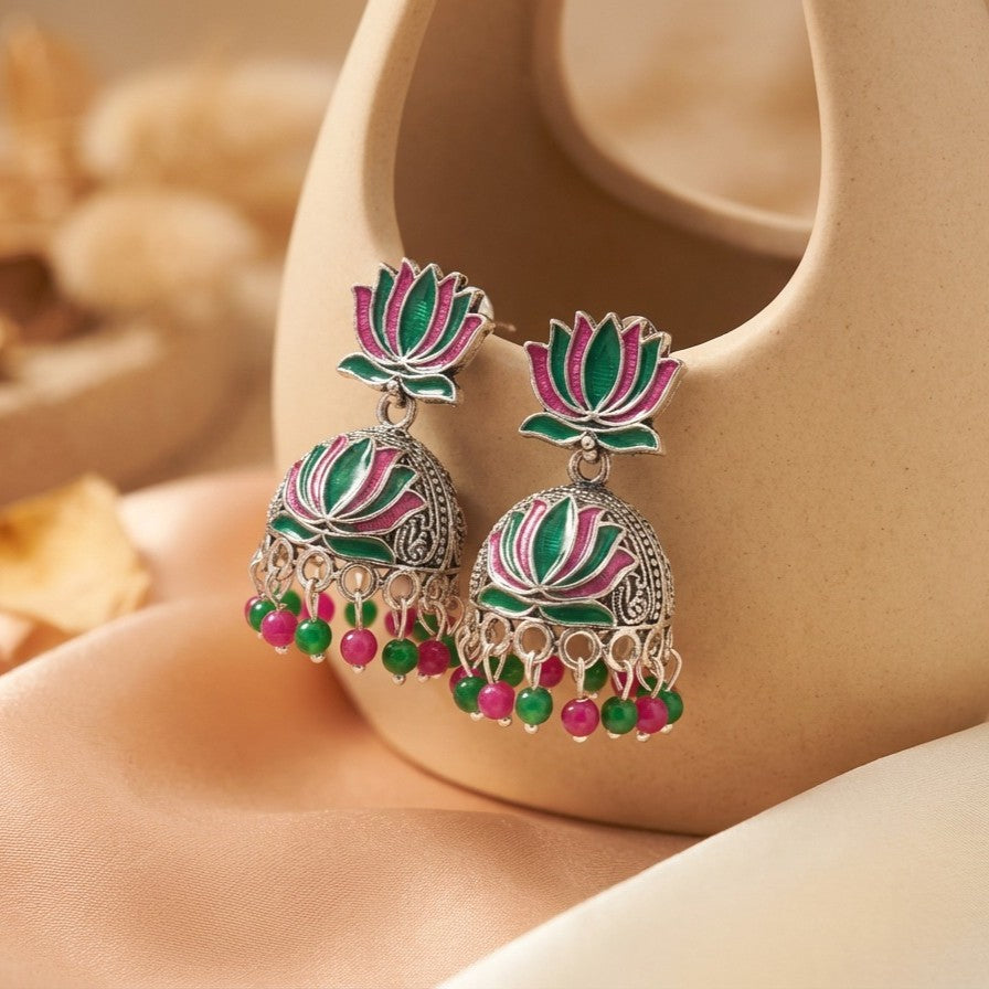 A vibrant celebration of tradition and color, this piece captures the charm of lotus-inspired elegance with a playful festive touch. The blooming motif paired with lively red and green bead drops creates a graceful movement that feels joyful, eye-catching, and beautifully rooted in culture.