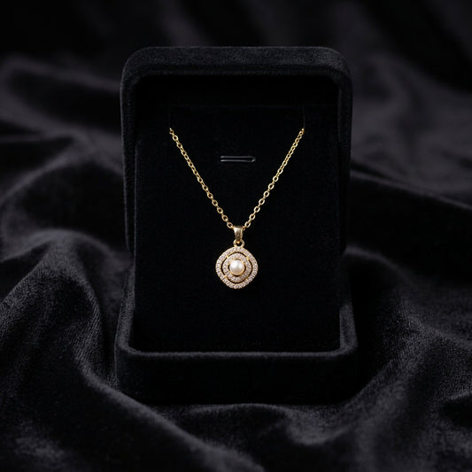 A delicate pearl framed within shimmering crystal layers, this necklace carries a soft radiant charm that feels timeless and elegant. Its minimal silhouette and graceful sparkle make it the perfect everyday piece with a luxurious feminine touch.