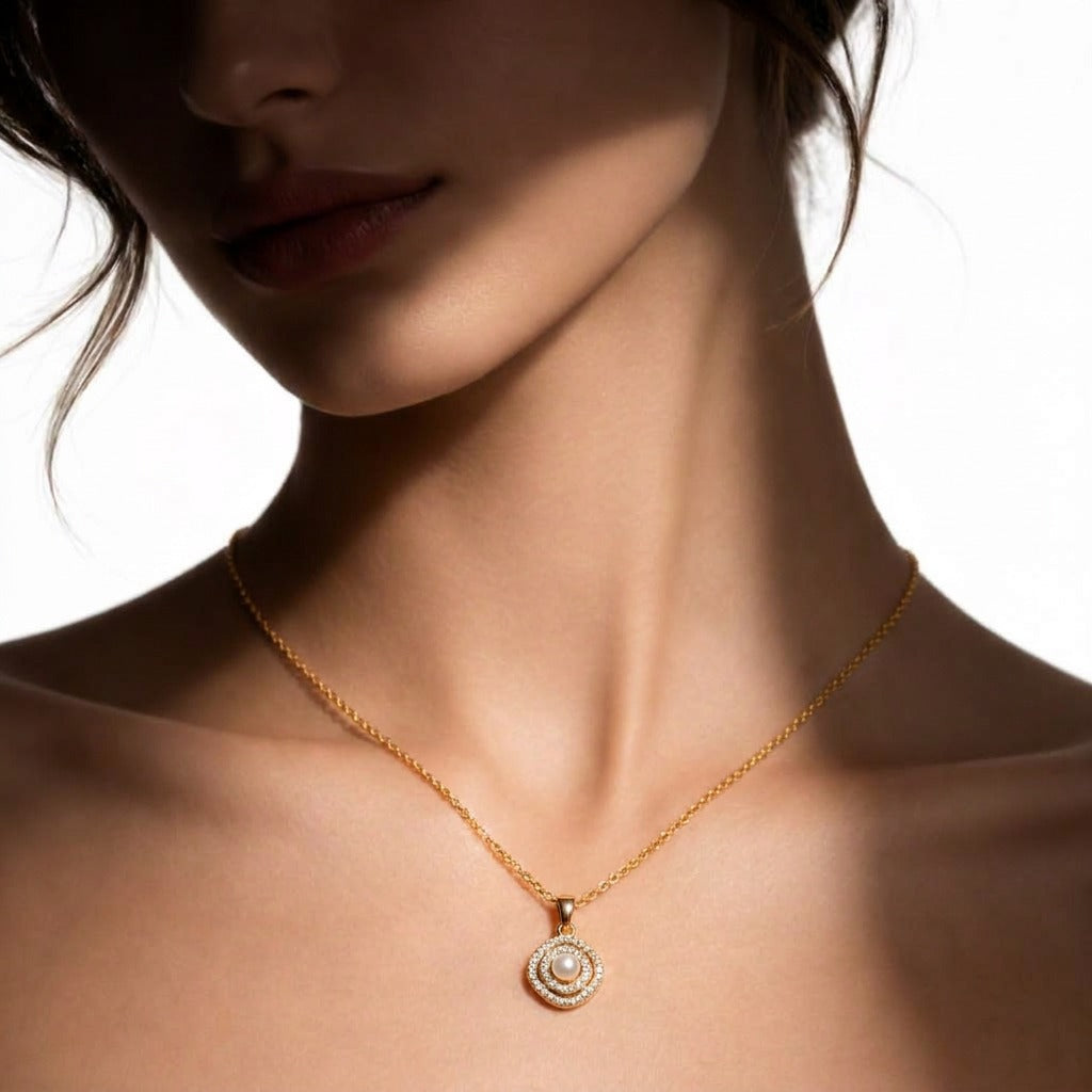 A delicate pearl framed within shimmering crystal layers, this necklace carries a soft radiant charm that feels timeless and elegant. Its minimal silhouette and graceful sparkle make it the perfect everyday piece with a luxurious feminine touch.