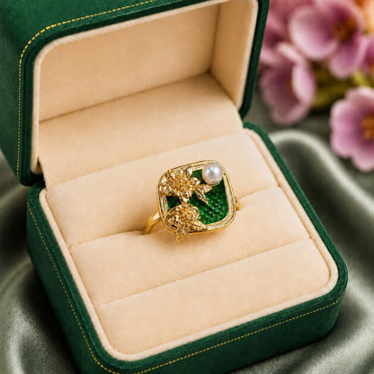 Like a hidden garden framed in gold, this elegant ring captures a graceful blend of blooming florals, luminous pearl beauty, and vintage-inspired charm. Featuring sculpted golden flowers over rich enamel detailing with a delicate pearl accent, it creates a refined statement that feels artistic, feminine, and effortlessly luxurious.