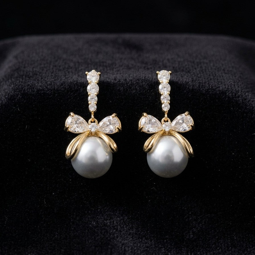 A soft cascade of pearls tied with elegance the Pearl Ribbon Drops blend delicate charm with graceful movement. Designed with a bow-inspired top and flowing pearl strands, these earrings create a romantic silhouette that feels light, feminine, and effortlessly refined. Each drop sways gently with every step, adding a subtle glow to both everyday looks and special moments
