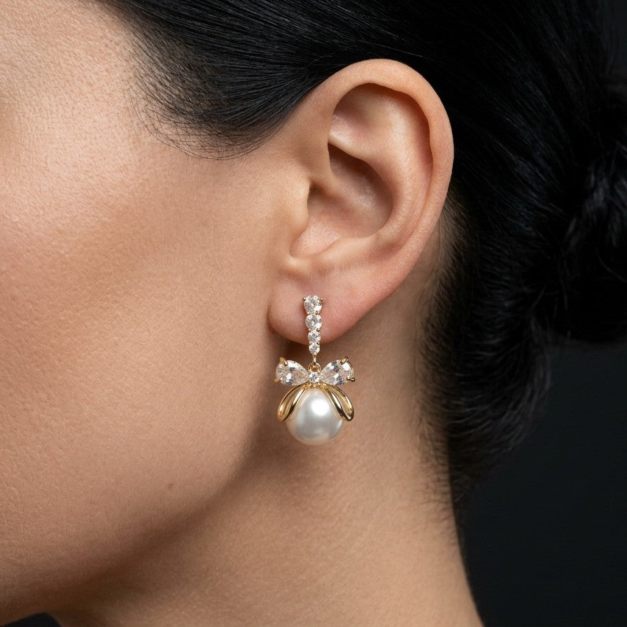 A soft cascade of pearls tied with elegance the Pearl Ribbon Drops blend delicate charm with graceful movement. Designed with a bow-inspired top and flowing pearl strands, these earrings create a romantic silhouette that feels light, feminine, and effortlessly refined. Each drop sways gently with every step, adding a subtle glow to both everyday looks and special moments