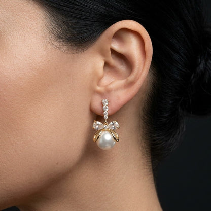 A soft cascade of pearls tied with elegance the Pearl Ribbon Drops blend delicate charm with graceful movement. Designed with a bow-inspired top and flowing pearl strands, these earrings create a romantic silhouette that feels light, feminine, and effortlessly refined. Each drop sways gently with every step, adding a subtle glow to both everyday looks and special moments