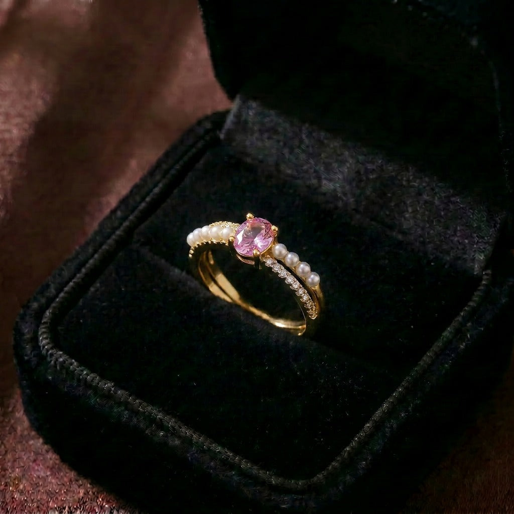 A delicate harmony of blush sparkle and pearl elegance, this ring features a soft pink gemstone embraced by luminous pearl accents and a crystal-lined band. Its graceful silhouette creates a dreamy statement that feels romantic, feminine, and effortlessly elegant.