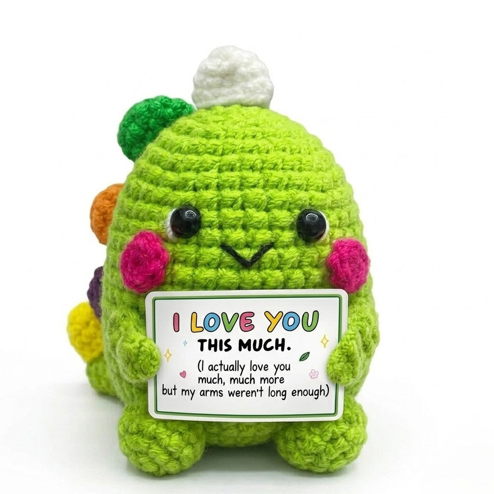 Crocheted character holding a 'I LOVE YOU THIS MUCH' sign on a white background