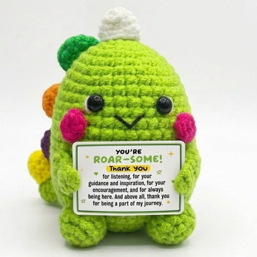 Green plush toy with a card saying 'You're Roar-some! Thank you' on a white background