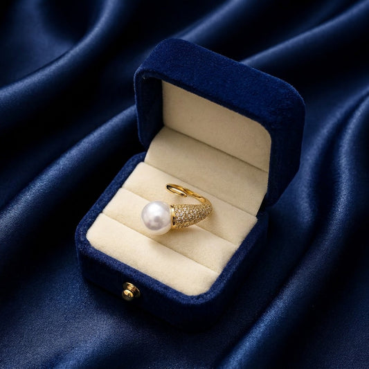 Command the room with the Seraphina Spear Ring, a piece that artfully blends sharp modern lines with the timeless luster of a pearl. This avant-garde design features a striking "spear" motif that directs all eyes toward a magnificent focal point, creating a look that is both edgy and undeniably sophisticated.