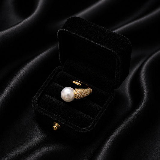 Command the room with the Seraphina Spear Ring, a piece that artfully blends sharp modern lines with the timeless luster of a pearl. This avant-garde design features a striking "spear" motif that directs all eyes toward a magnificent focal point, creating a look that is both edgy and undeniably sophisticated.