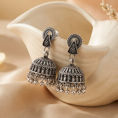 A refined blend of tradition and structure, the Sitara Jhumka captures the beauty of geometric elegance with a soft cultural touch. Its detailed dome and graceful arc design create a balanced look that feels both minimal and richly traditional.
