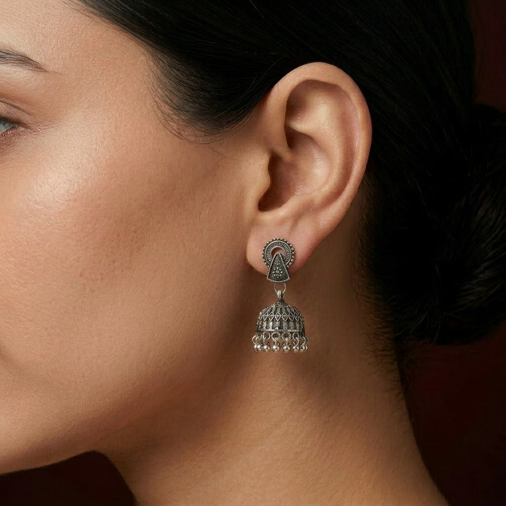 A refined blend of tradition and structure, the Sitara Jhumka captures the beauty of geometric elegance with a soft cultural touch. Its detailed dome and graceful arc design create a balanced look that feels both minimal and richly traditional.