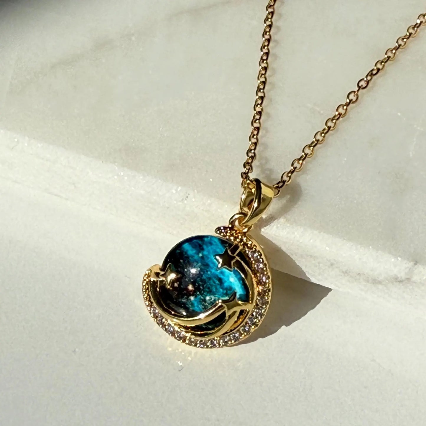 Unveil the elegance of the cosmos with the Stardust Whisper Necklace, a breathtaking creation crafted from premium titanium steel and plated with a durable titanium finish. This necklace features a mesmerizing cosmic-inspired pendant, adorned with glimmering zircon stones that catch the light from every angle.