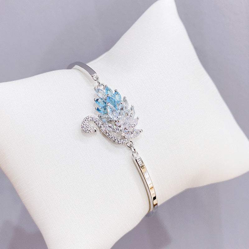A graceful swan silhouette with leaf-like crystals—minimal from afar, breathtaking up close. Swanveil Lumi Bracelet is that soft-luxury sparkle that instantly makes your wrist look polished and expensive.

