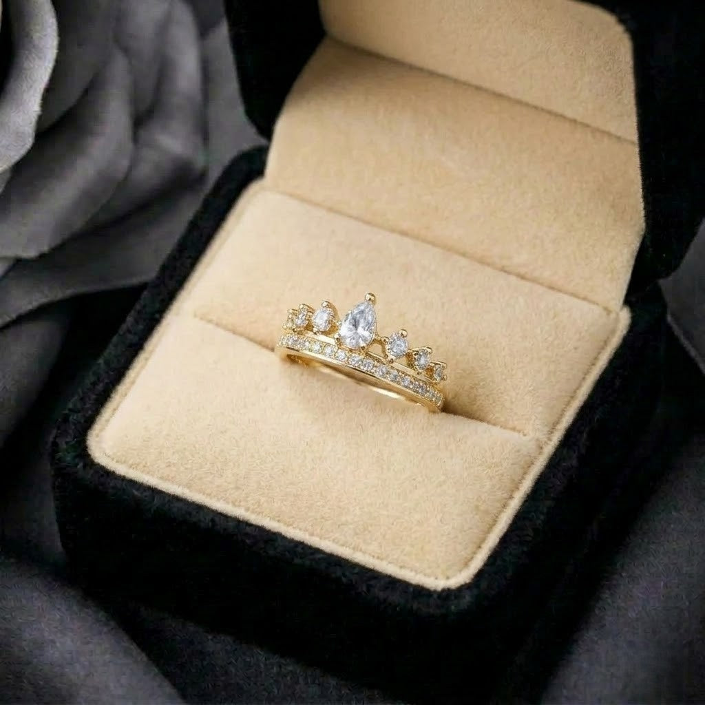 A graceful crown-inspired silhouette adorned with shimmering stones,&nbsp;Tiarabelle Ring captures the elegance of a tiny royal tiara wrapped around your finger. The pear-cut center crystal and sparkling accents create a look that feels delicate, regal, and timeless.