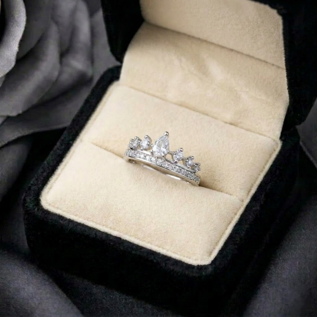 A graceful crown-inspired silhouette adorned with shimmering stones,&nbsp;Tiarabelle Ring captures the elegance of a tiny royal tiara wrapped around your finger. The pear-cut center crystal and sparkling accents create a look that feels delicate, regal, and timeless.