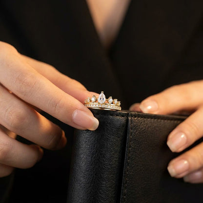 A graceful crown-inspired silhouette adorned with shimmering stones, Tiarabelle Ring captures the elegance of a tiny royal tiara wrapped around your finger. The pear-cut center crystal and sparkling accents create a look that feels delicate, regal, and timeless.