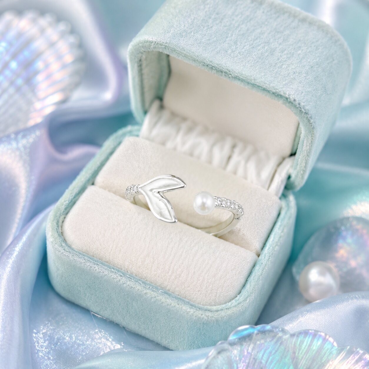 A graceful meeting of ocean tides and timeless elegance, this ring features a delicate pearl paired with a flowing whale-tail-inspired silhouette. Its airy open design and shimmering accents create a soft coastal charm that feels serene, feminine, and effortlessly unique.