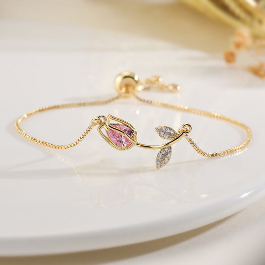Delicate, graceful, and endlessly poetic, the Tulip Tuned Bracelet captures the quiet beauty of a budding flower ready to bloom. Its tulip-shaped charm, set with a soft pink crystal embraced by gold-plated copper vines, glimmers like morning light on dew-kissed petals.