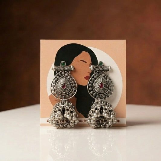 A bold expression of strength wrapped in elegance, this piece blends intricate craftsmanship with a powerful, heritage-inspired silhouette. The teardrop centerpiece paired with detailed engraving and cascading ghungroo drops creates a striking movement that feels both fierce and beautifully refined.