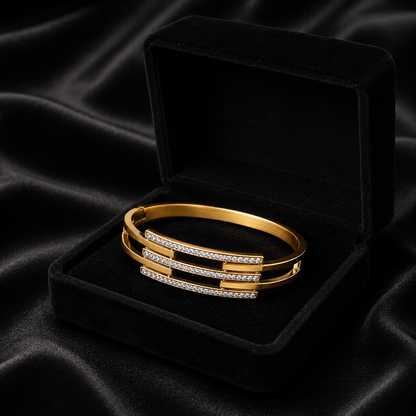 A refined play of clean lines and crystal brilliance, this cuff captures modern elegance in a sleek layered silhouette. The parallel crystal bars paired with a polished gold finish create a statement look that feels both bold and effortlessly sophisticated.