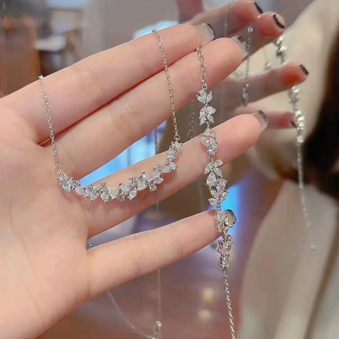 Graceful as falling petals in spring light, the Wisteria Petal Set glistens with pure sophistication. Each zircon stone is delicately cut and arranged in a floral flow, forming a soft cascade of brilliance that mirrors nature’s poetry. Crafted with premium zircon and finished with precision.