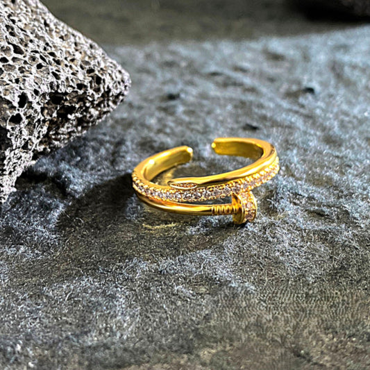 Crafted with a smooth high-polish gold-tone finish, this open cuff-style ring features a sleek nail-inspired design adorned with delicate micro-stone detailing that catches the light effortlessly. The adjustable open structure ensures a comfortable fit, making it perfect for statement styling or everyday luxury layering.